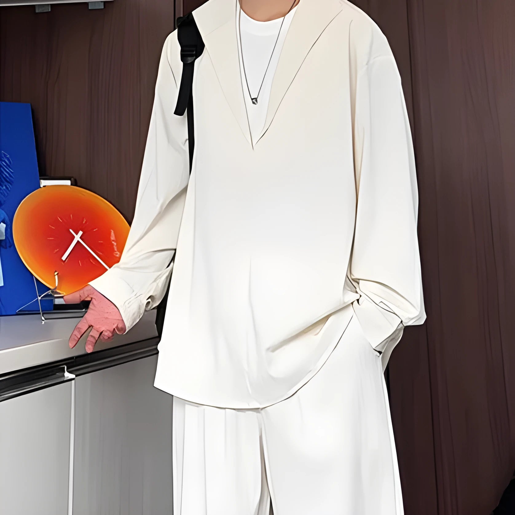 Man wearing a slim fit apricot long sleeve polo shirt and matching trousers from a casual two-piece suit set.