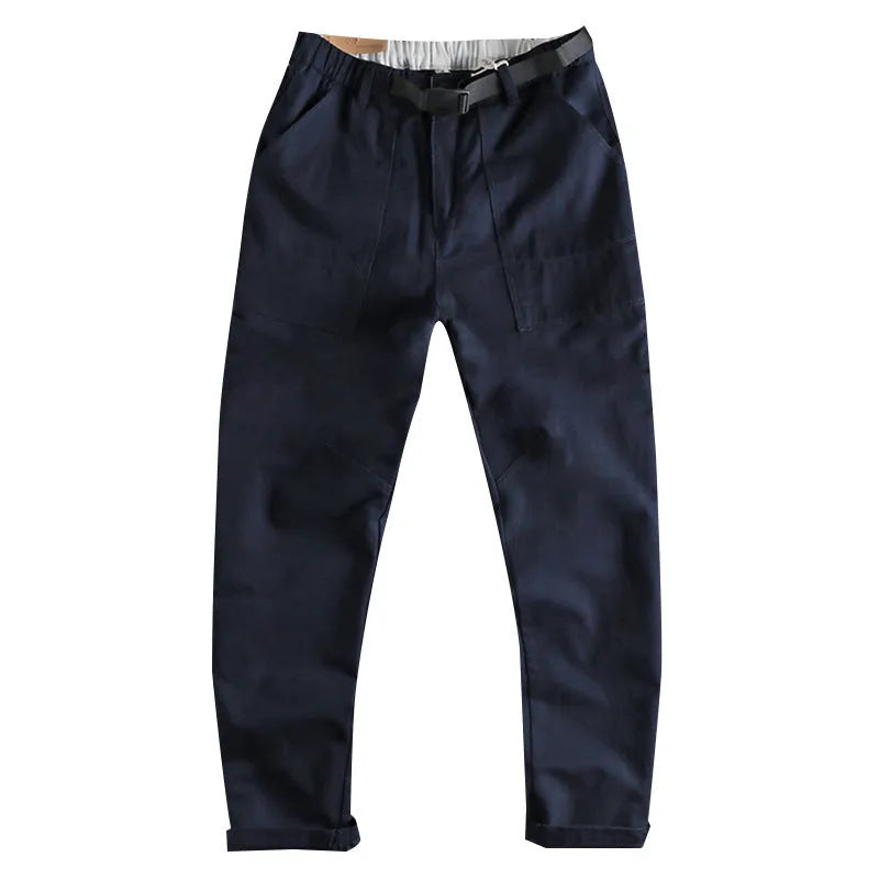 Men's khaki trousers with N buckle belt closure and zipper fly on a mid-waist fit.