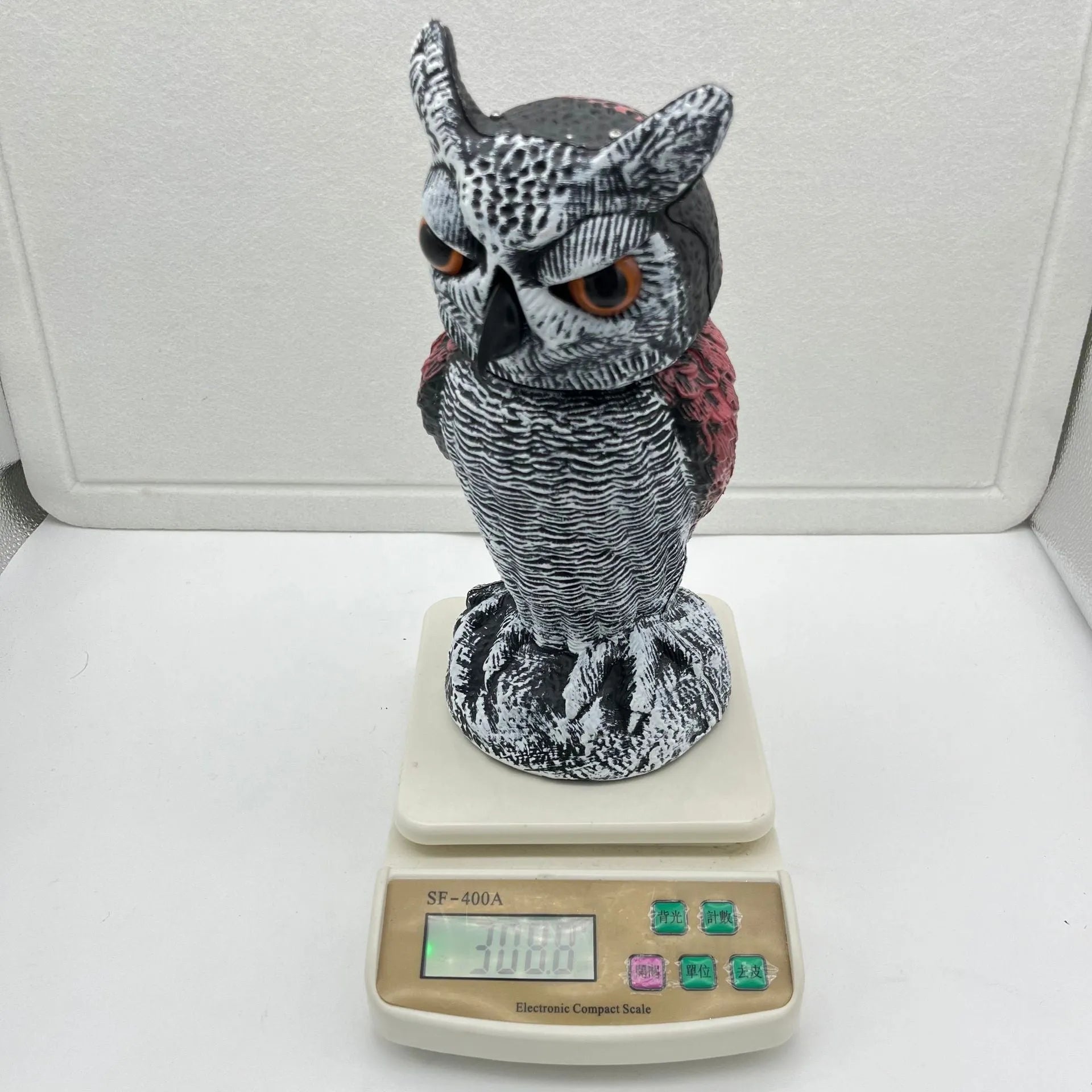 Artificial owl garden ornament with shaking head for bird deterrent on patio