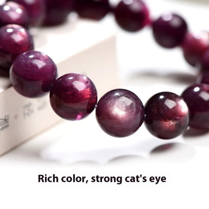 Natural purple lepidolite crystal round bead bracelet showing polished beads on a cord.