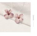 A pair of flower-shaped stud earrings for women in either pink or white alloy with an electroplated finish.