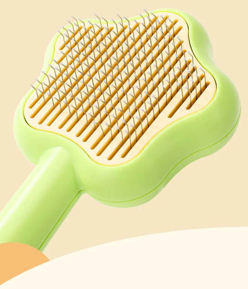 Green self-cleaning stainless steel pet comb for grooming cats and dogs on a white background