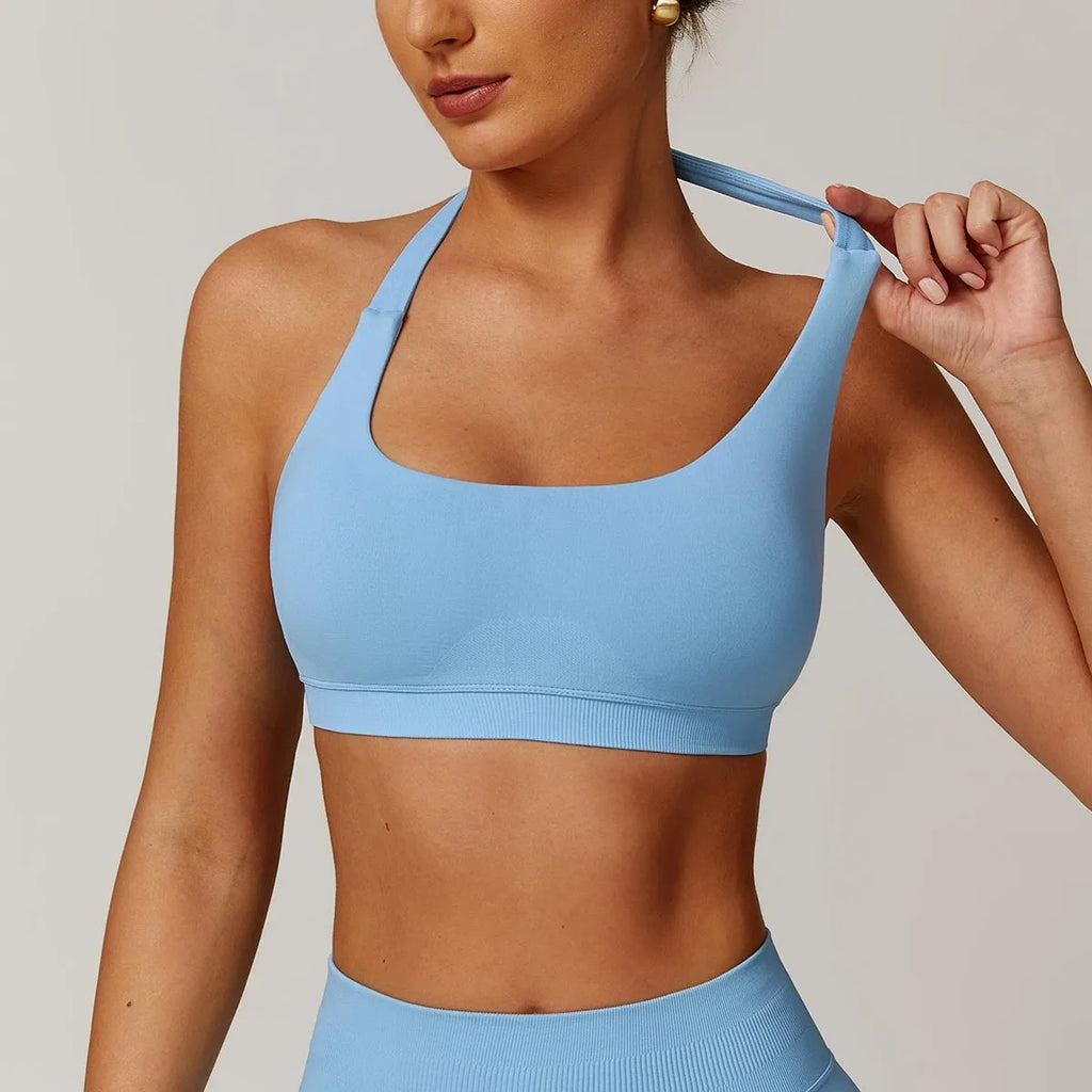 Women's halter style sports bra in black with medium support and built-in chest pads