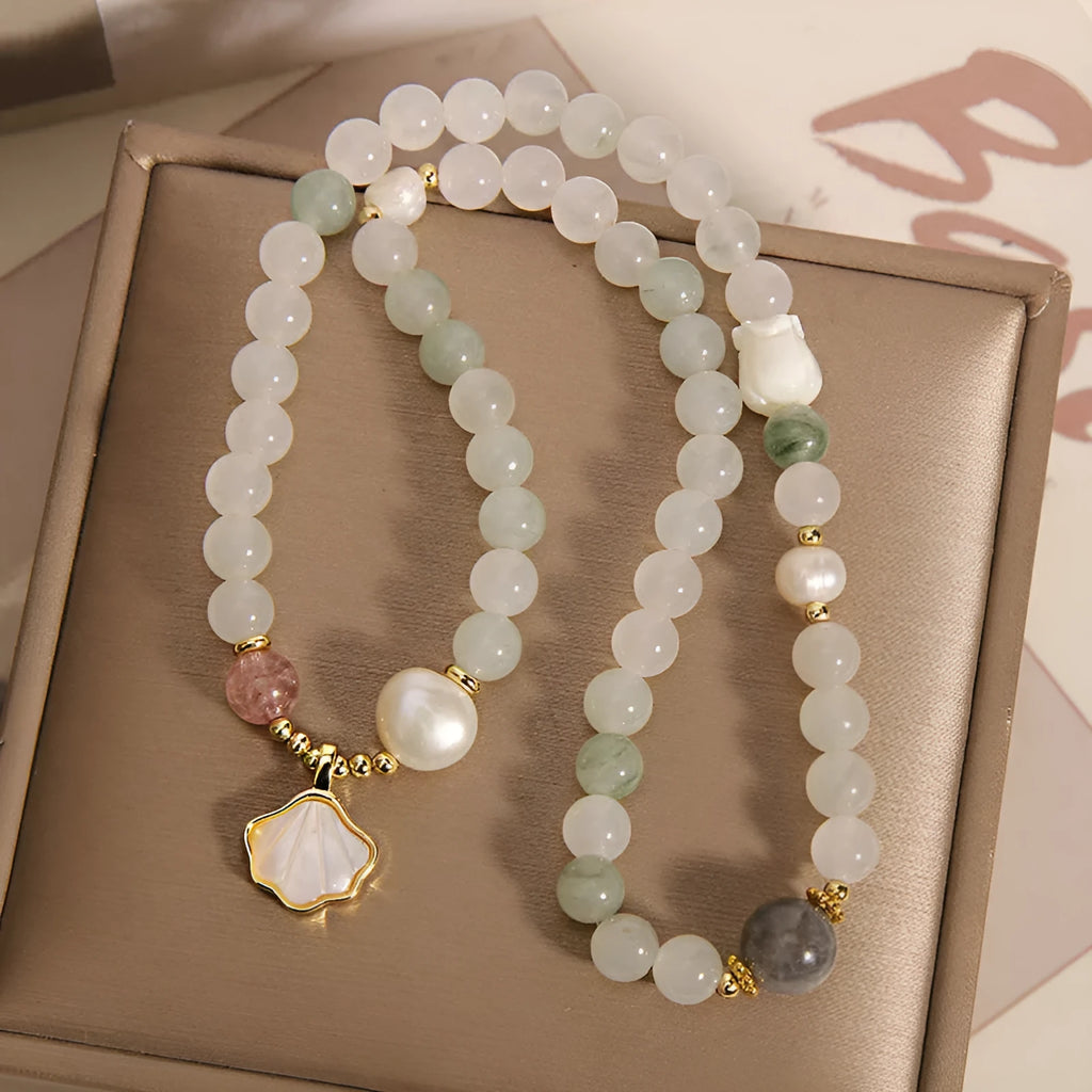 Women's crystal bracelet with green ginkgo leaf pendant, gold accents and rhinestones