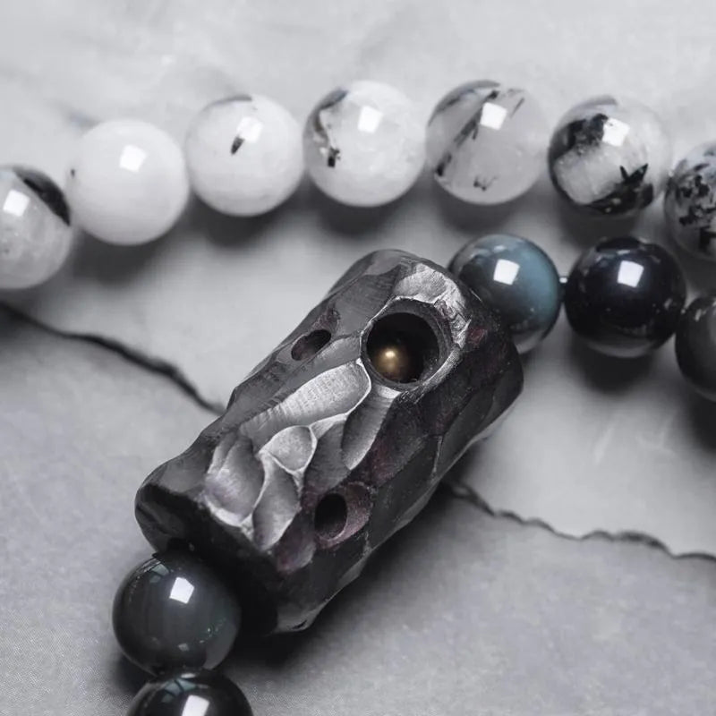 Black hair crystal bracelet with white crystal tassel and bending and lacing design on neutral background