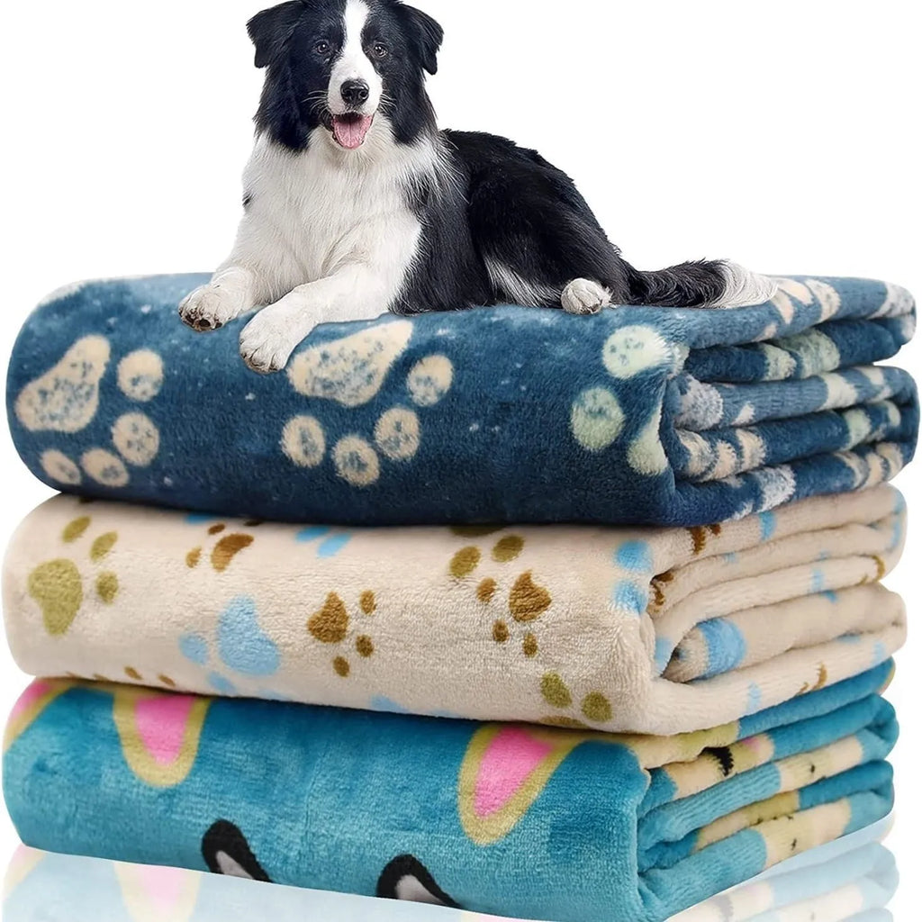Blue cartoon dog pattern double-sided flannel pet blanket shown on a dog bed.