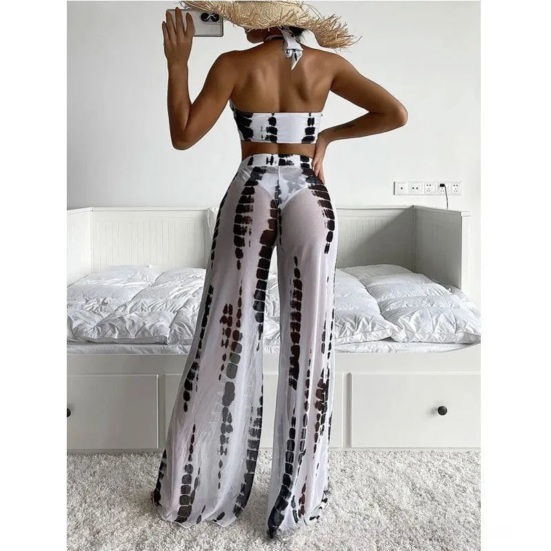 Women's black and blue printed three-piece swimsuit set with bikini top and mesh trousers.