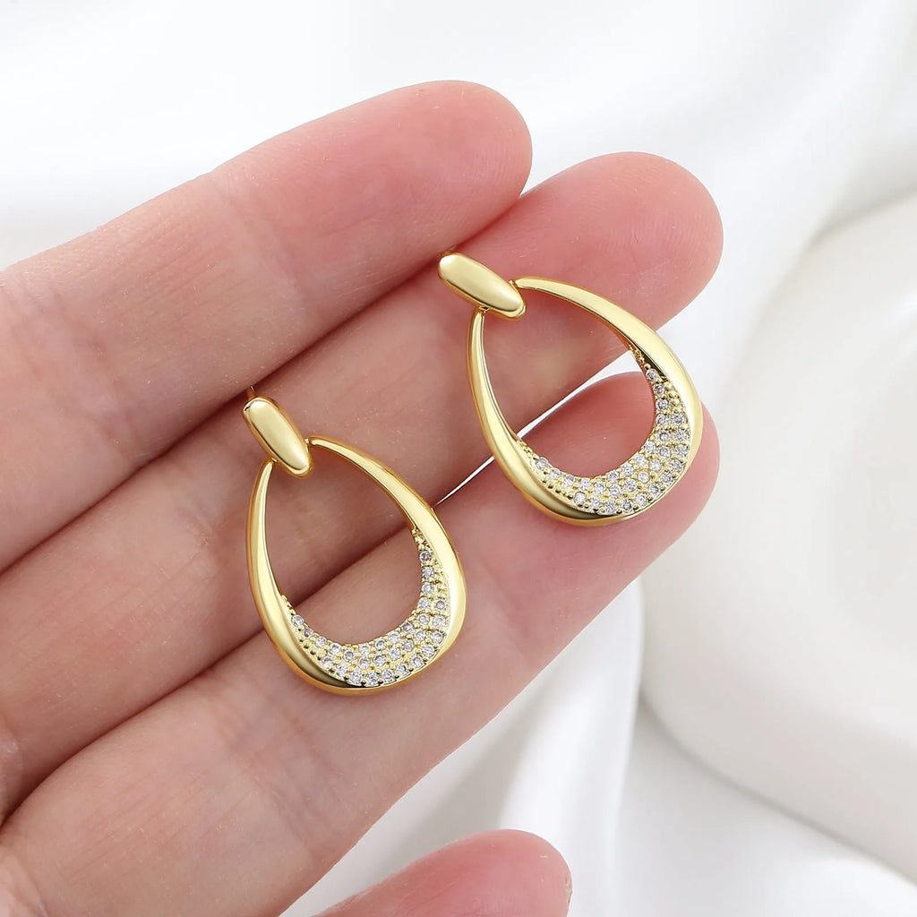 Women's yellow gold geometric drop earrings with simple zircon detail showing oval and round design elements