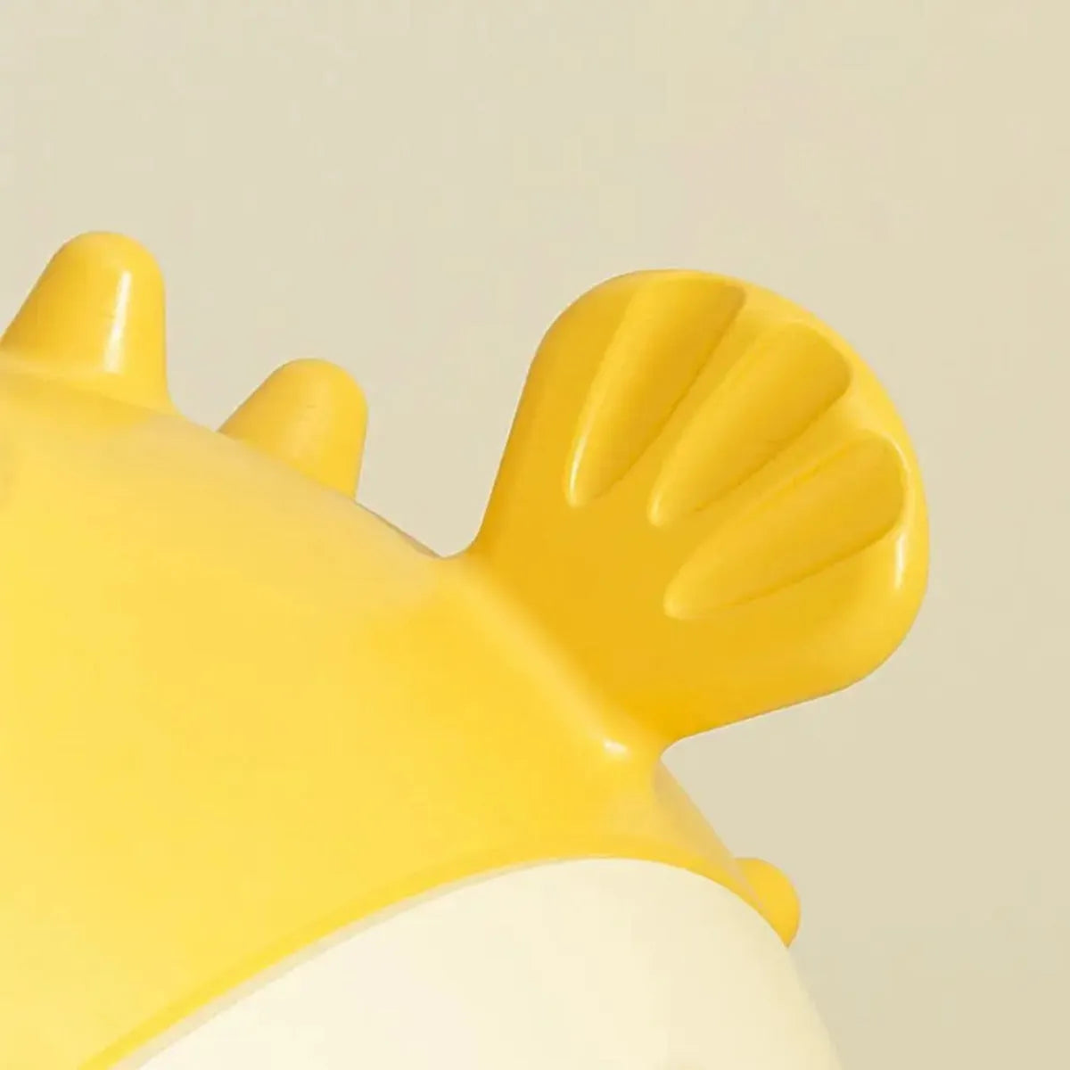 Yellow fish-shaped vinyl dog chew toy with textured surface and squeaker inside.