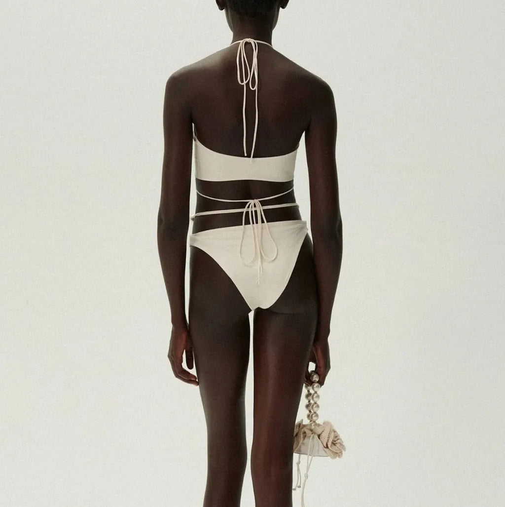 Women's split lace-up bikini swimsuit in black, two-piece set with bra and shorts on plain background