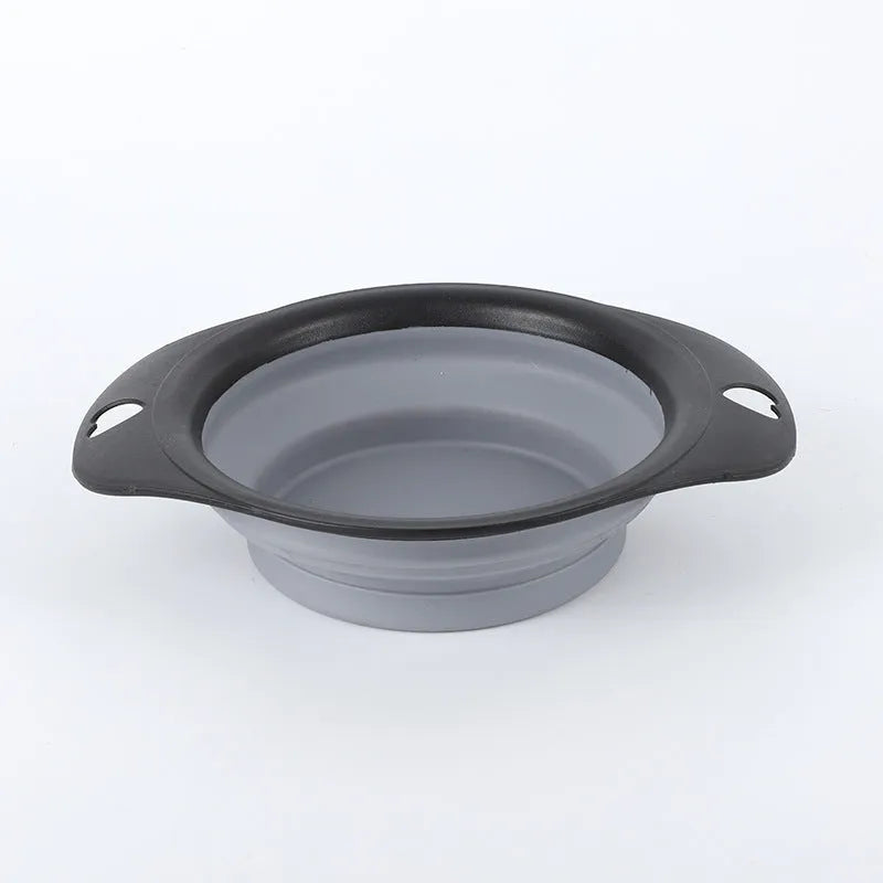 Silicone folding bowl for pets in black and green, collapsed flat for storage, portable outdoor cat and dog food bowl