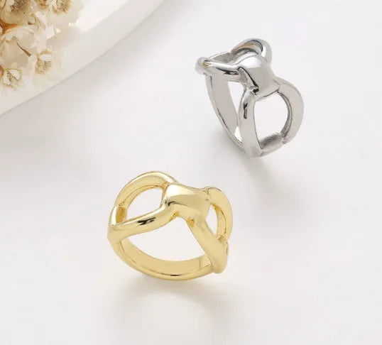 Simple fashion butterfly hollow women's ring in titanium steel gold colour on plain background