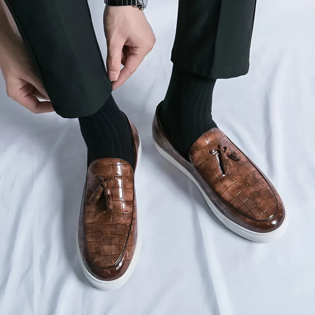 Men's black tassel detail leather-look sneakers on a white background, side view.