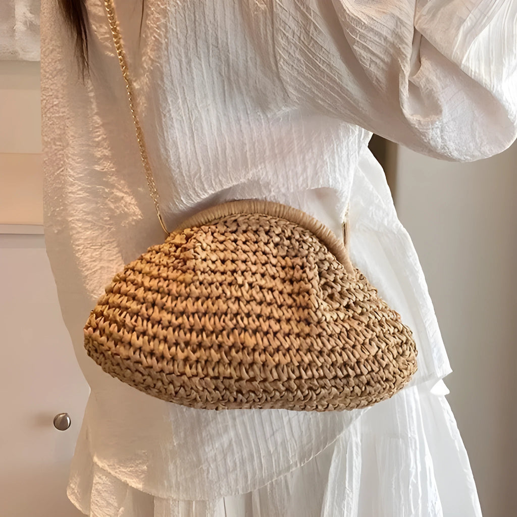 Women's beige straw shoulder bag with chain detail and a zippered interior.