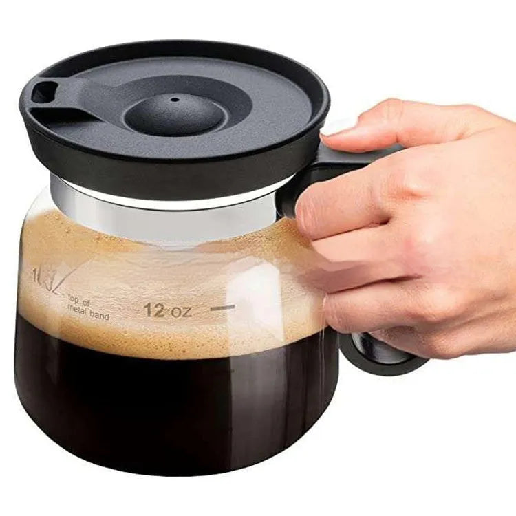 Transparent borosilicate glass coffee maker with black silicone thermal cover on a kitchen counter.