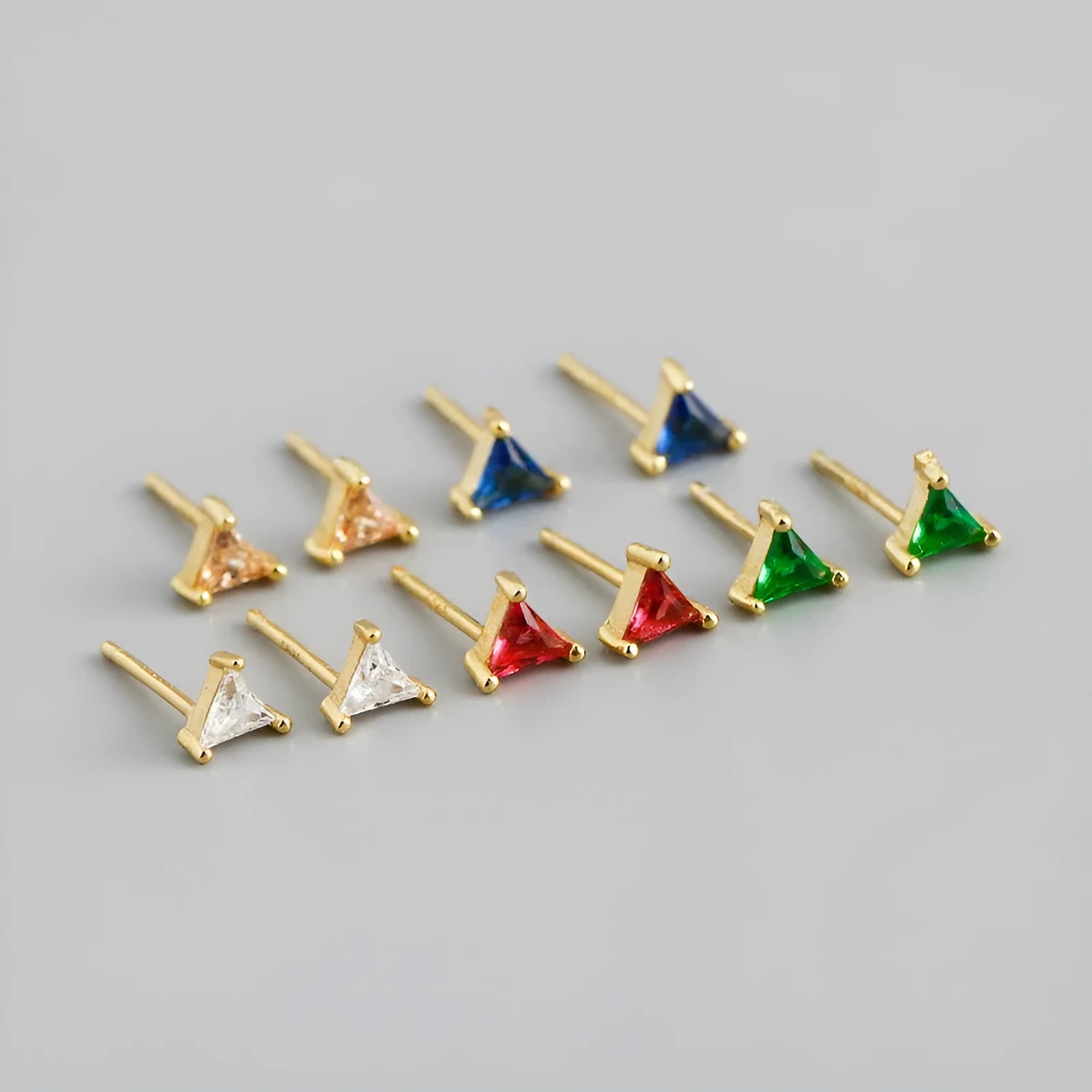 Simple triangle colour zircon stud earrings in 925 sterling silver with blue stone and gold needle on white background