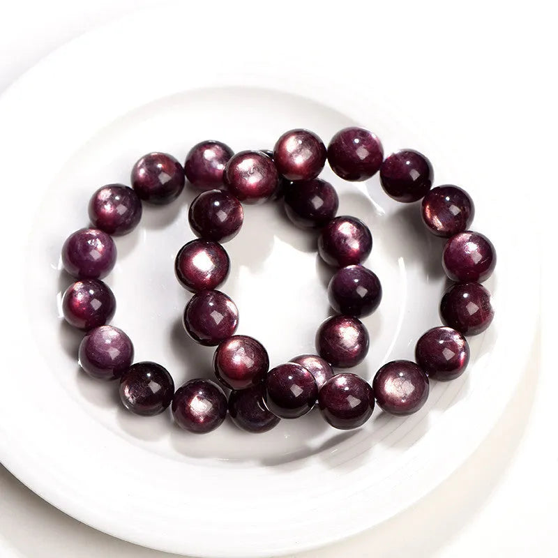Natural purple lepidolite crystal round bead bracelet showing polished beads on a cord.