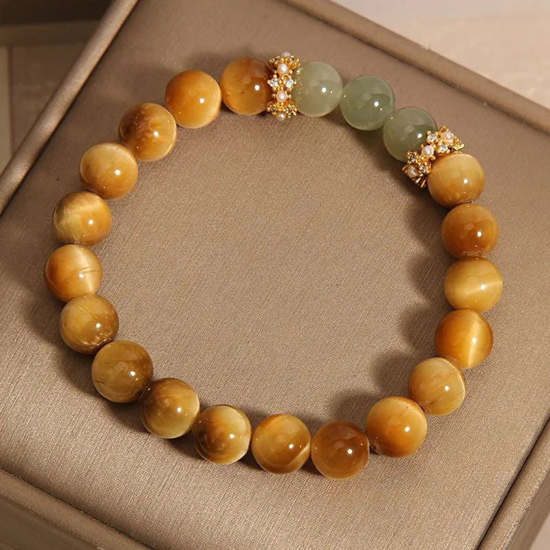 Natural yellow tiger's eye bracelet with U-shaped design showing auspicious patterns and traditional symbolic charms