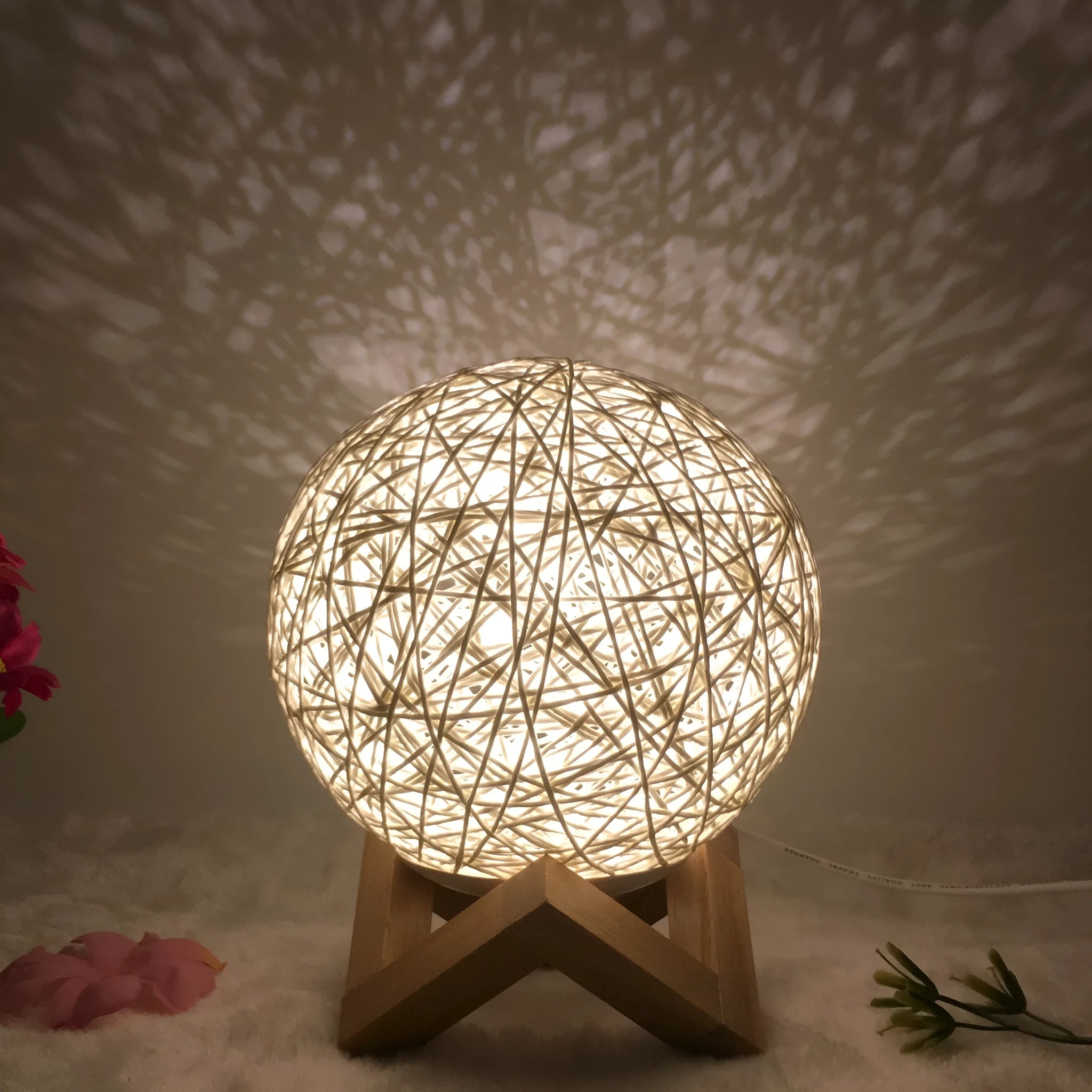 Hand-knit rattan LED table lamp with USB cable and remote control on table