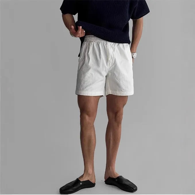 Men's loose fit cotton sports shorts in black, shown on a hanger.