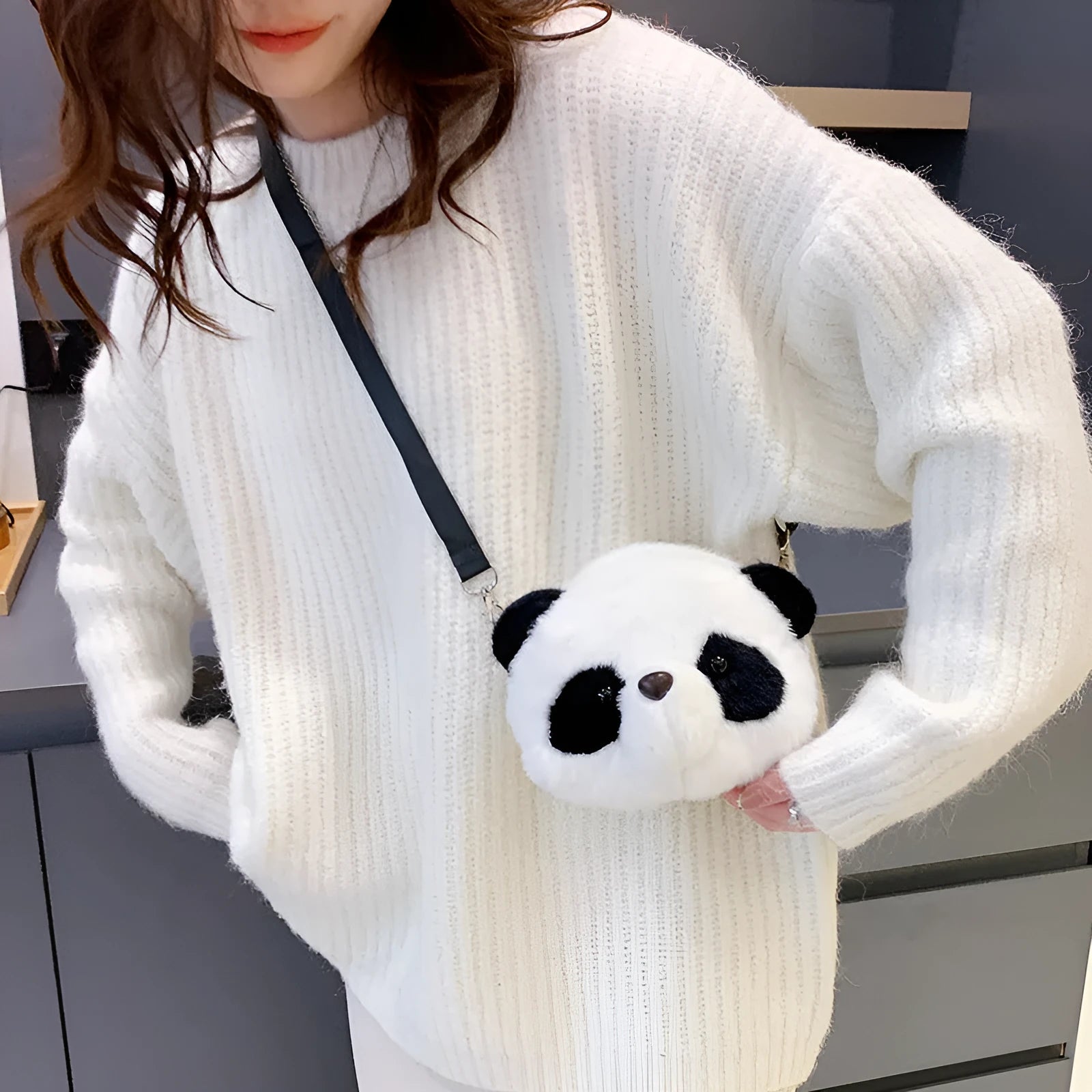 Soft plush crossbody bag with panda head design, cylindrical shape, and outer pocket.