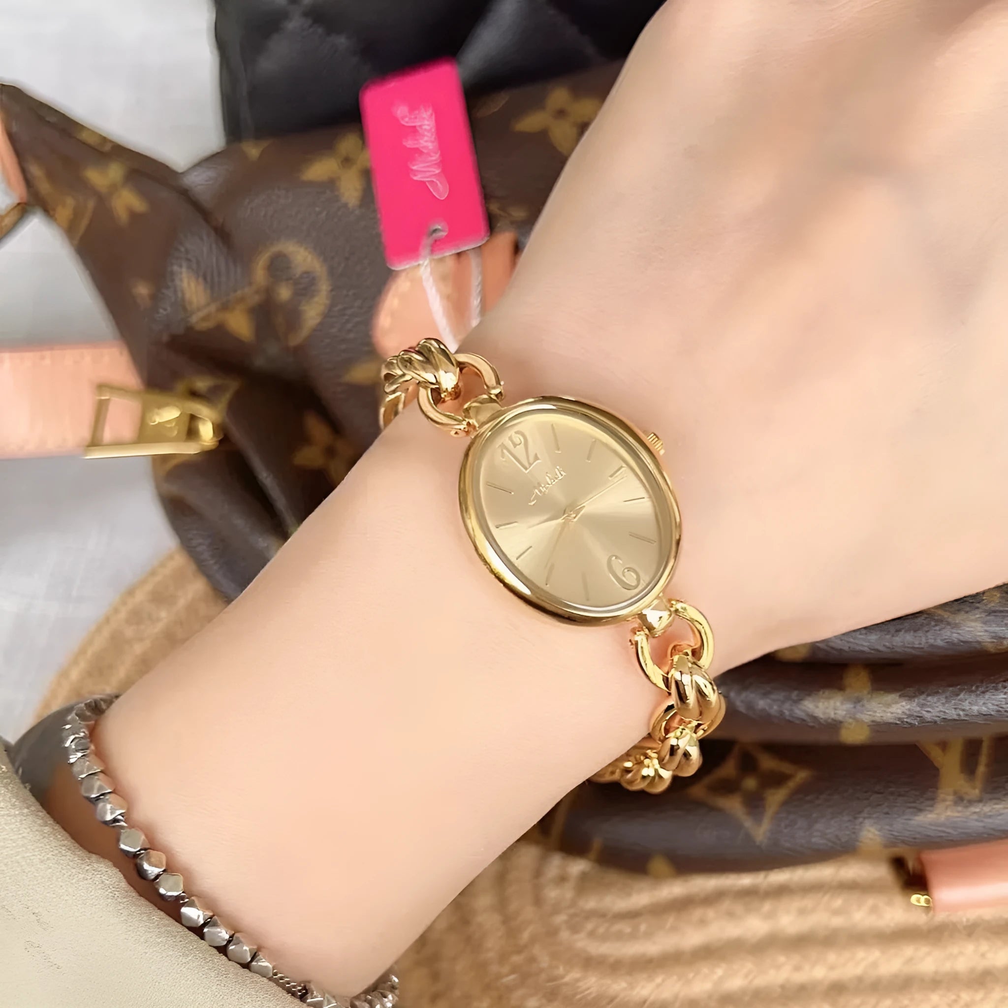 Lady's steel strap quartz watch with oval hollow chain in gold case gold face design