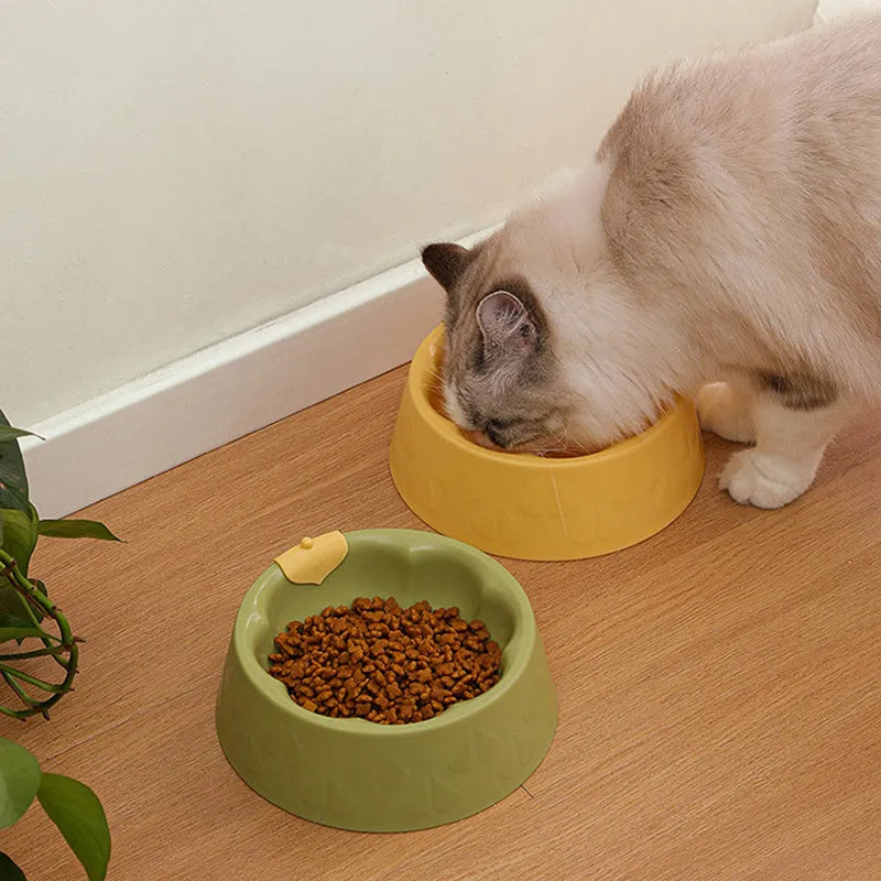 Green and yellow plastic double pet bowl for food and water on a flat surface.