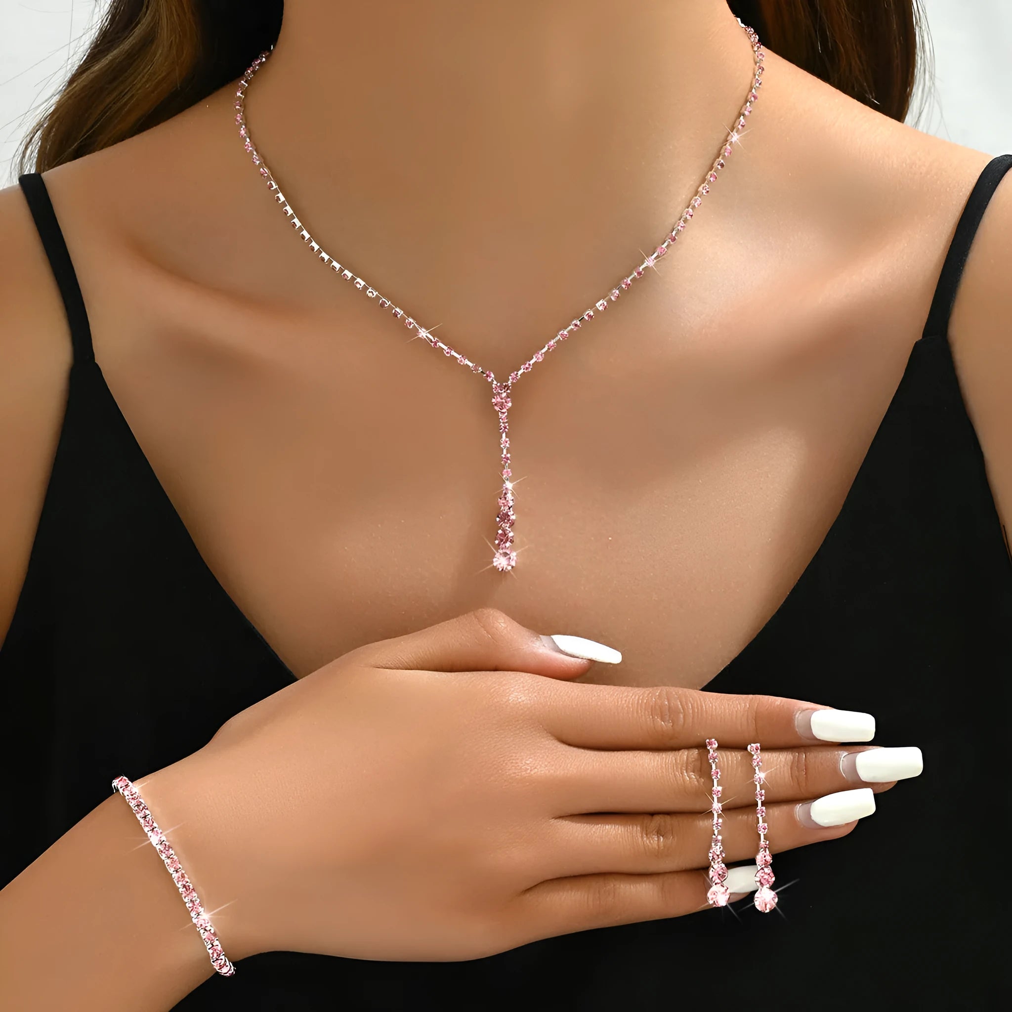 Rhinestone bridal jewellery set includes necklace, bracelet, and earrings in silver with tassel and heart elements