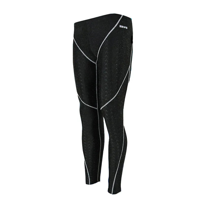 Men's nylon swimming trunks in black with grey trim, showing cropped brief style with mesh lining