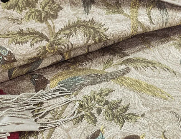 Blue cotton bedspread set with American floral and bird pattern laid on a bed.