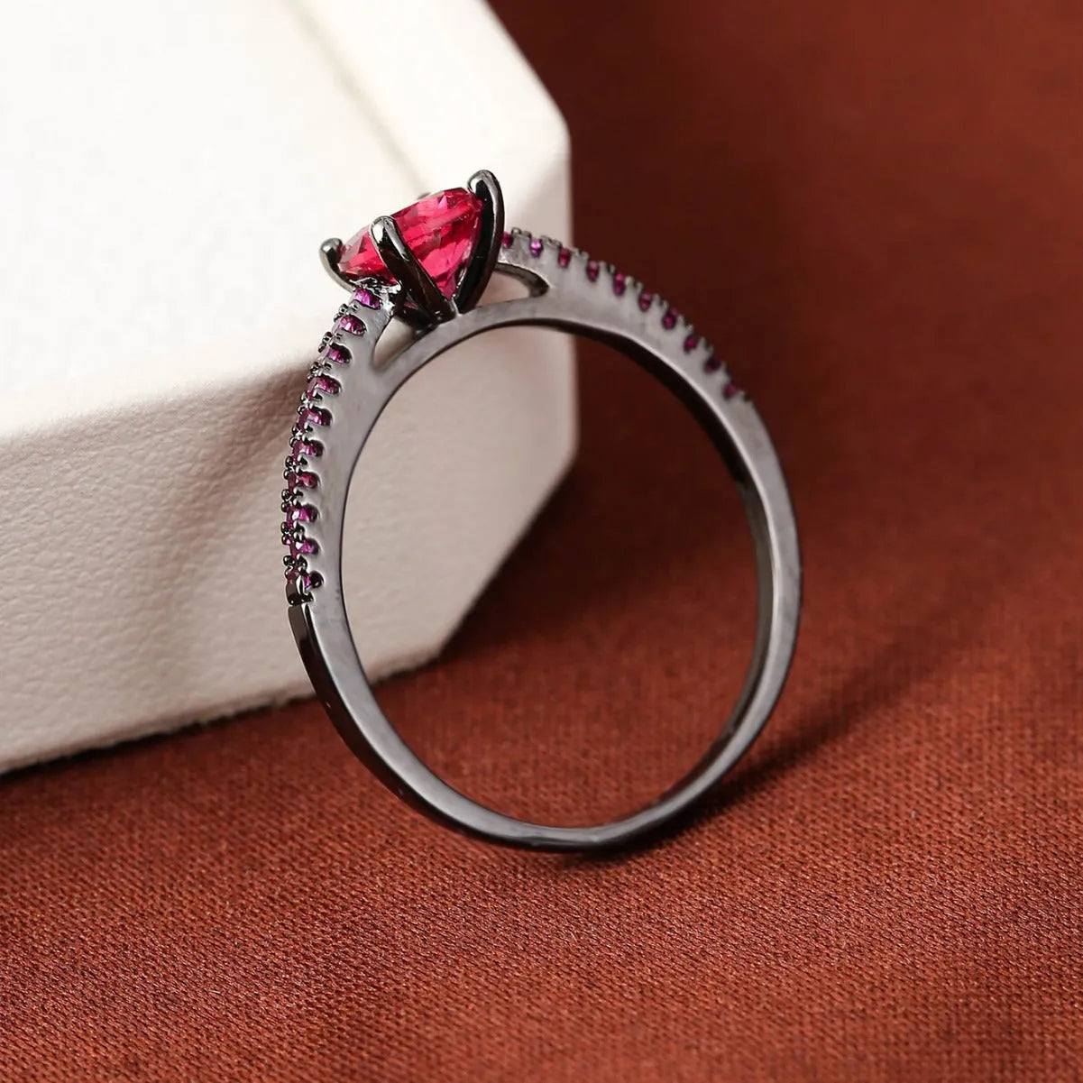 A hexagonal geometric ring made of copper with an electroplated finish, shown in a gold rose red colour.