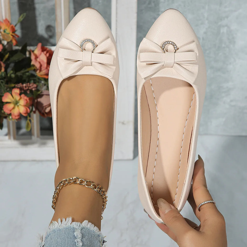 Women's beige casual flat loafers with a bowknot on the front, showing the shallow mouth and rubber sole.