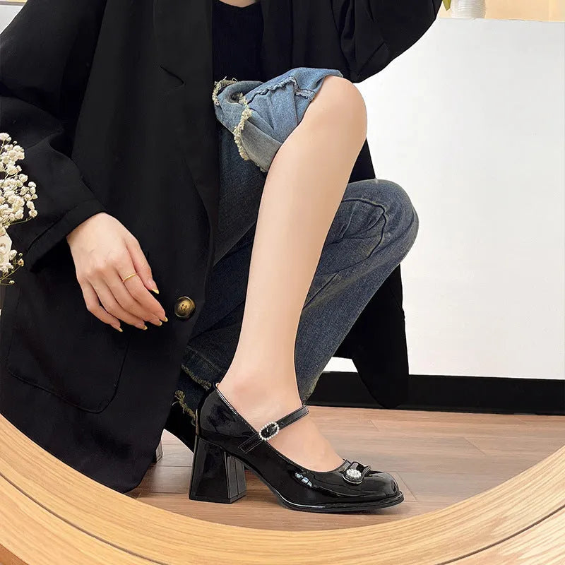 Women's black patent leather wide fit high heels with a round toe and chunky heel.