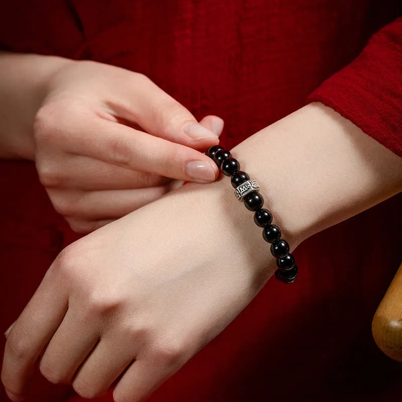 An ethnic-style women's bracelet made from 8mm obsidian beads with zodiac animal and Buddhist bodhisattva charms.
