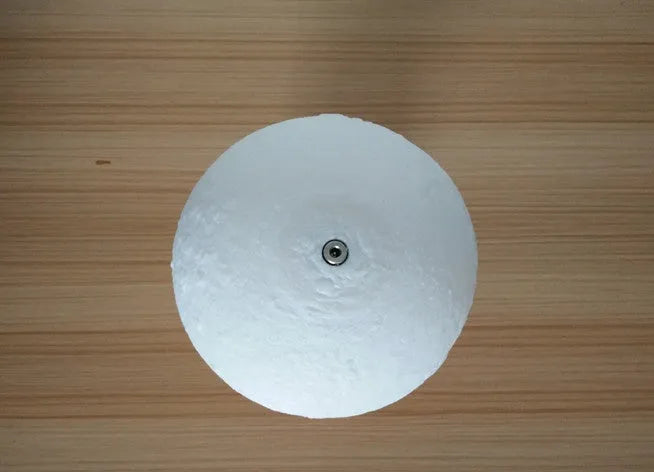 Luna Tranquil Moon Lamp with realistic moon texture and touch colour control on a bedside table