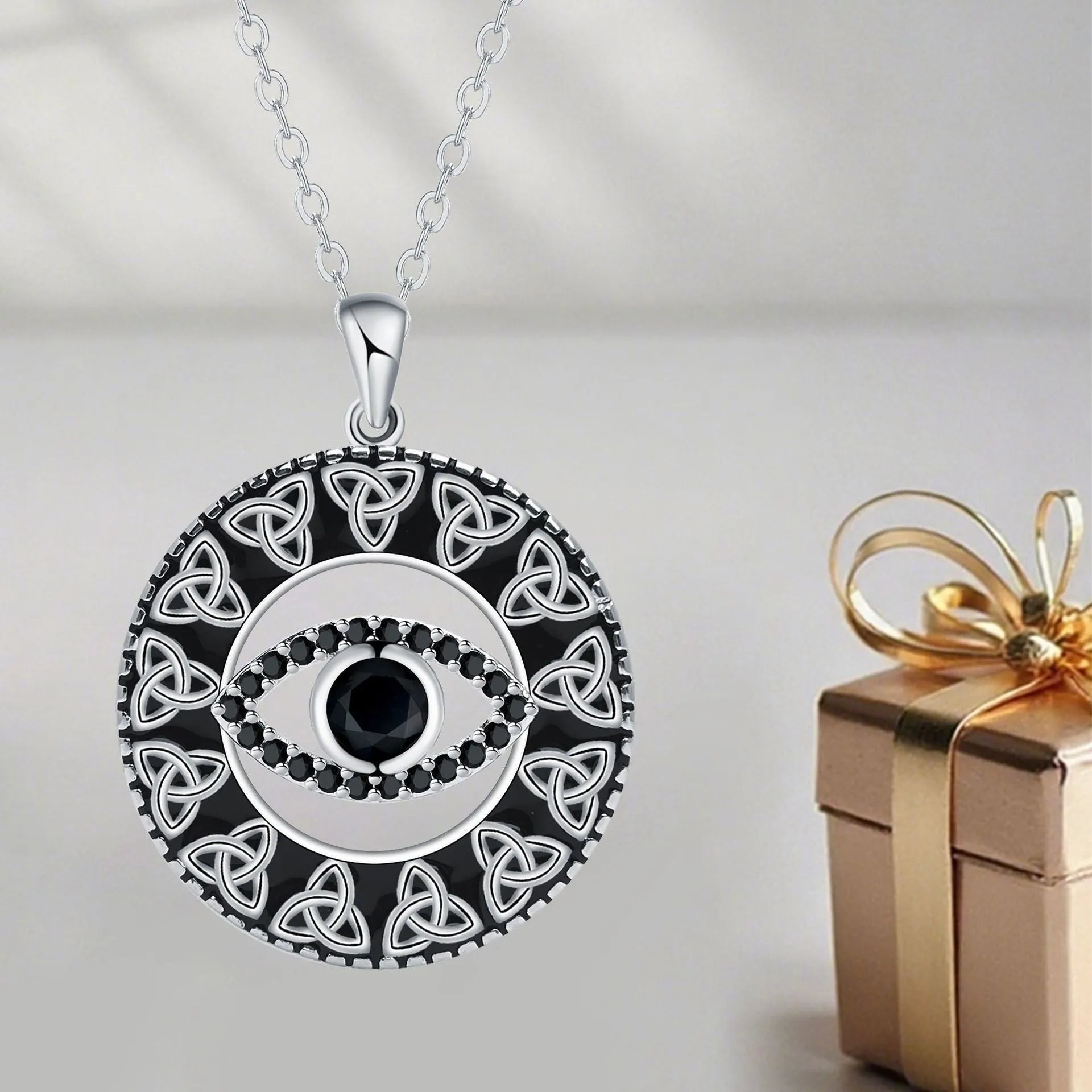 Copper Devil's Eye pendant necklace with cross chain and electroplated finish on display