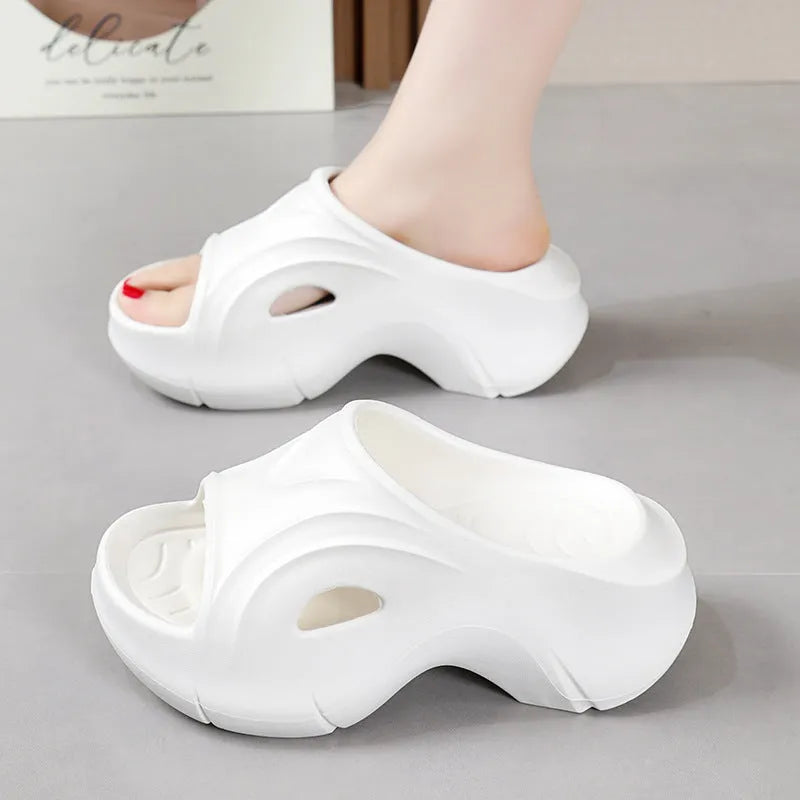 Women's thick-soled EVA slippers in rose red, white and black colours on a beach background.