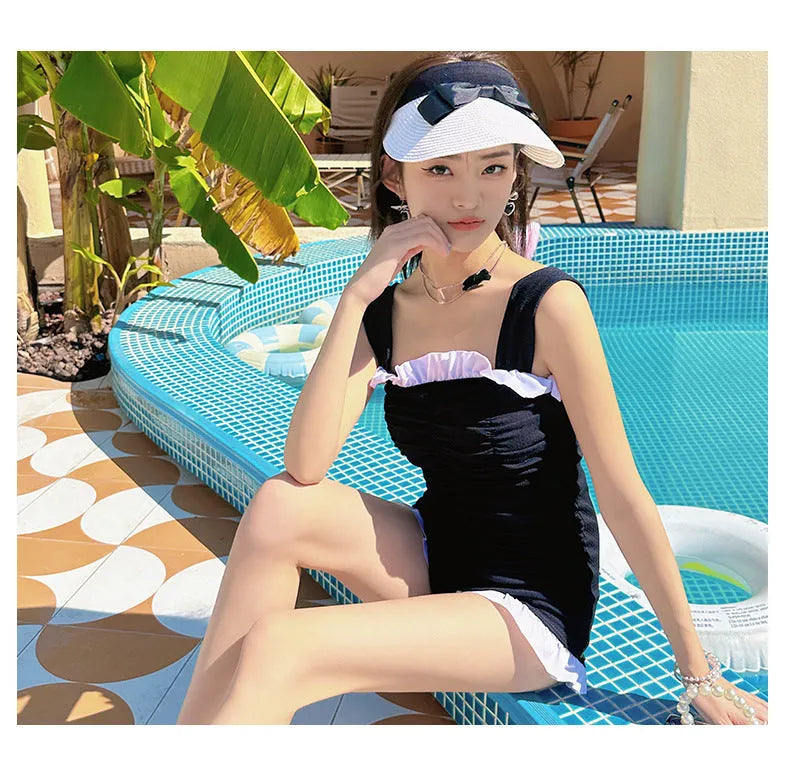 Women's solid colour one-piece suspender swimsuit in black, front view, polyester fibre, sizes S to XL