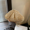 Women's beige straw shoulder bag with chain detail and a zippered interior.