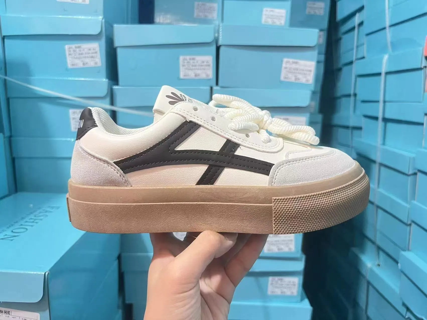 Blue and brown low-top women's borad shoes with patent leather upper and flat rubber sole.