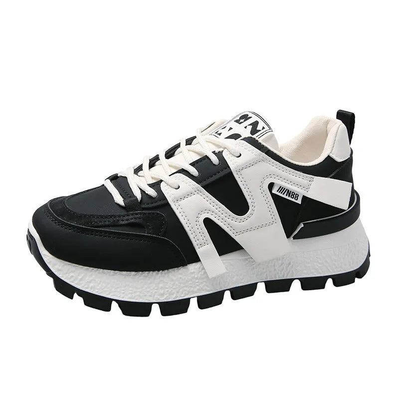 Low-top white and black casual sneakers with round toe and lace-up closure on a plain background.