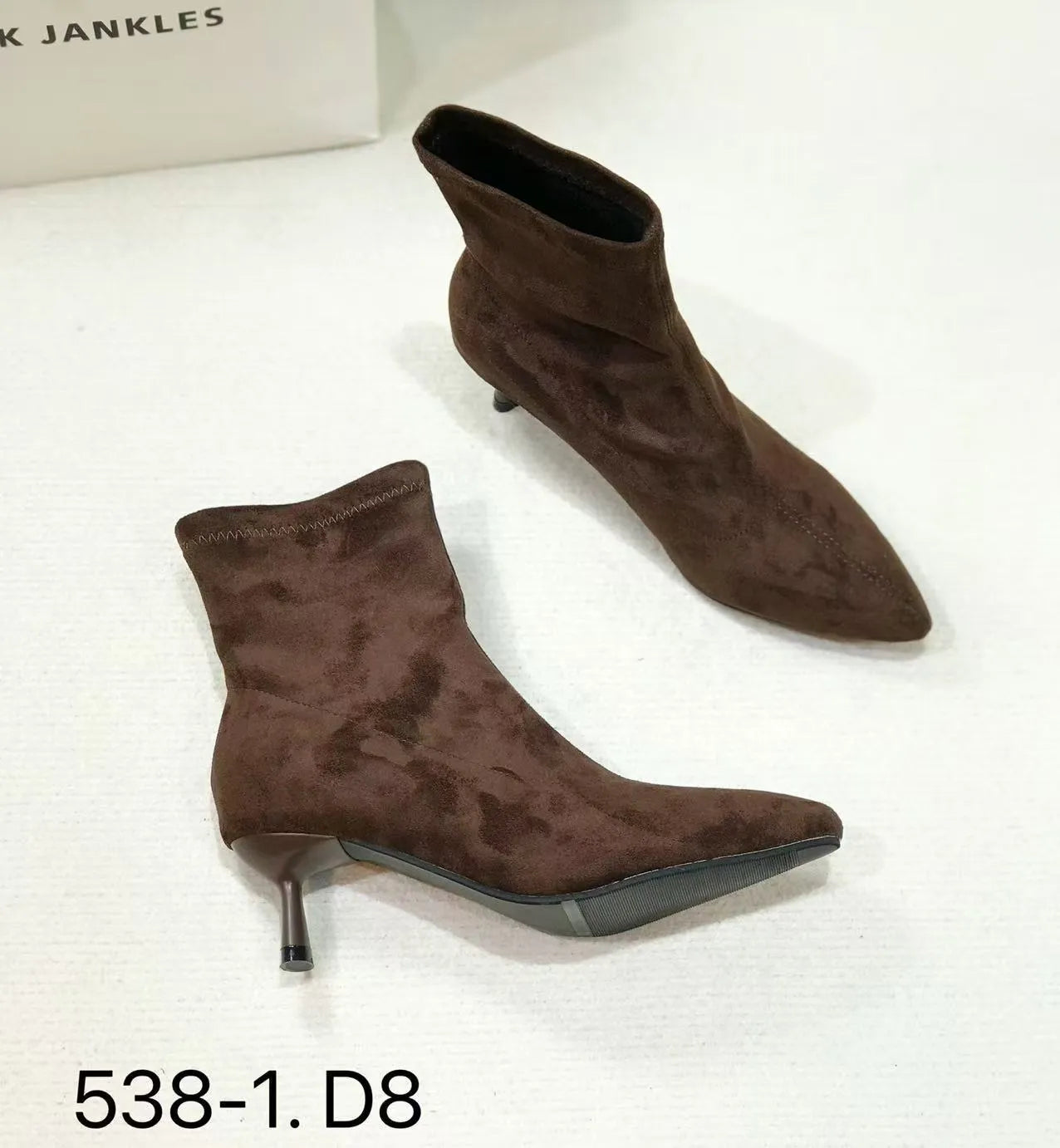 Black pointed toe ankle boots with a stiletto heel on a white background