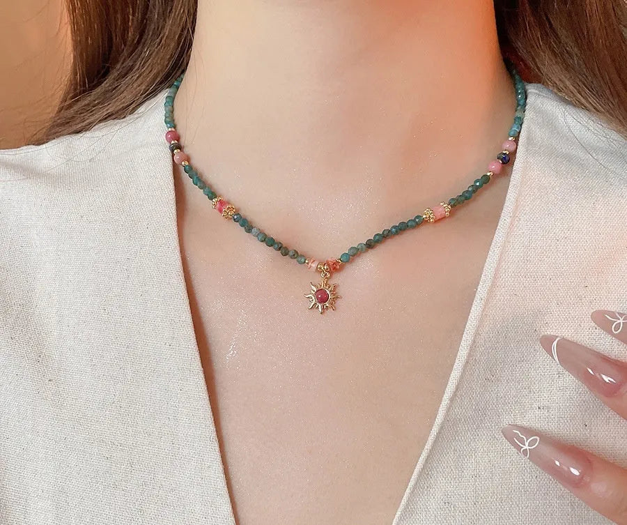 French royal style sun necklace with stone pendant, electroplated finish, and stringed freshwater pearls on a clavicle chain.