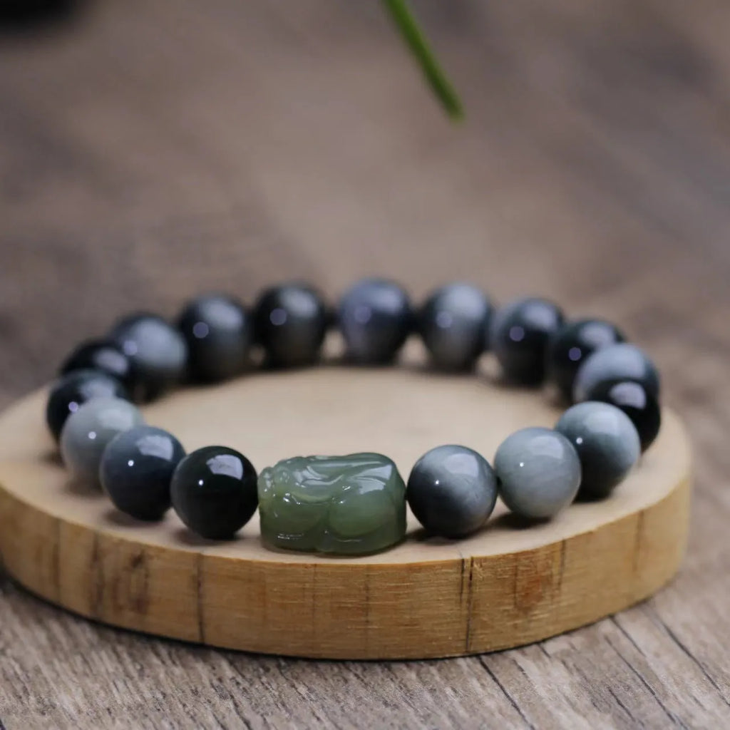10mm black eagle eye stone and natural Hetian jade clear water Pixiu bracelet on a neutral background