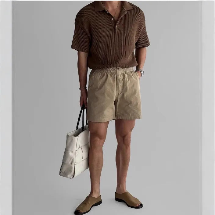 Men's loose fit cotton sports shorts in black, shown on a hanger.