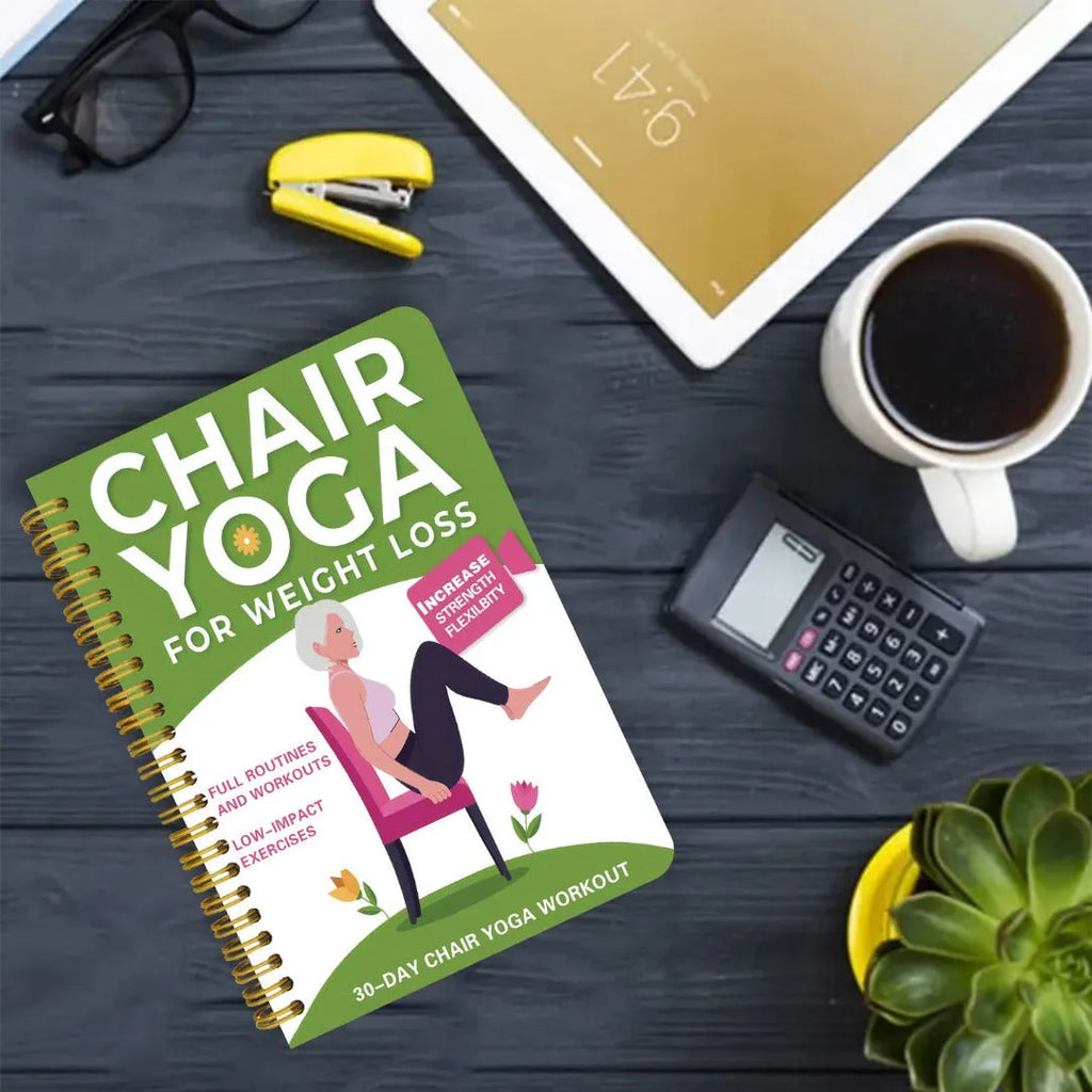 Green coil-bound 30-day chair yoga training guide notebook with calendar layout on a desk