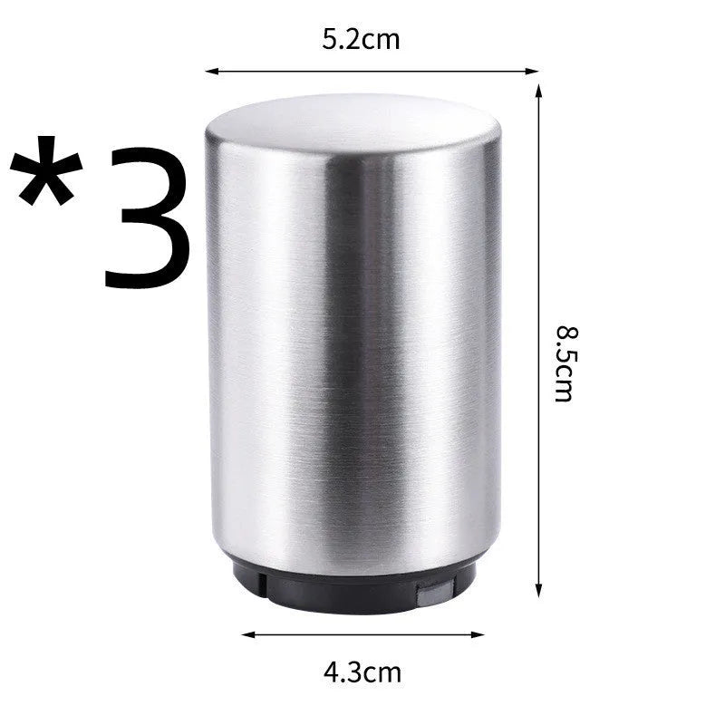 Automatic stainless steel beer bottle opener with magnetic cap catch on a table