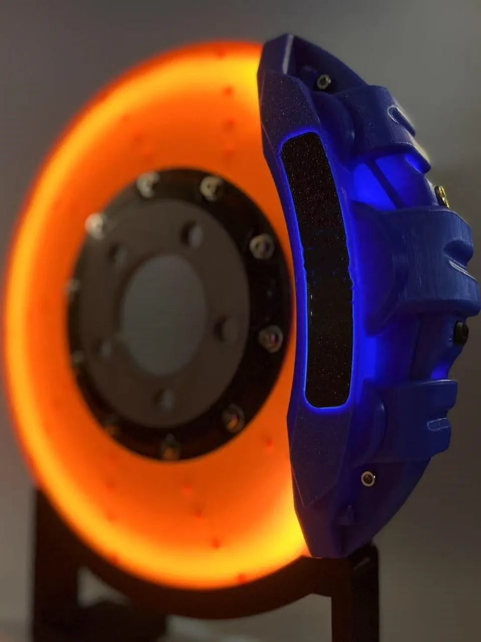 Rechargeable brake disc LED night light with touch dimmer, blue caliper colour, on a desk