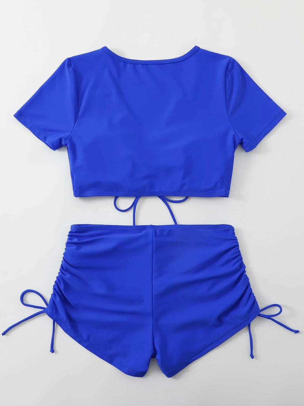 Women's dark green lace-up bow swimsuit top with matching shorts laid flat.