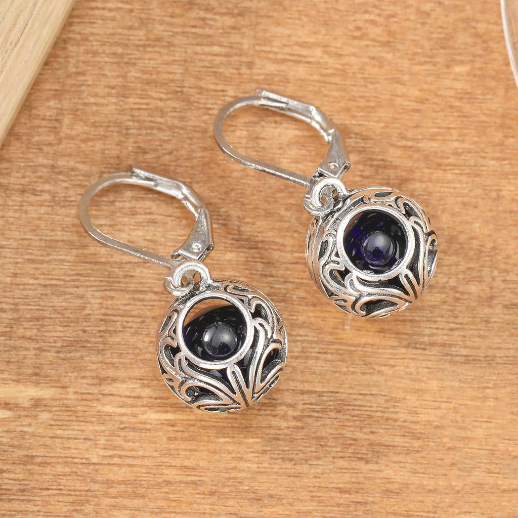 Vintage silver hollow pendant earrings with blue gemstone accent on geometric drop shape